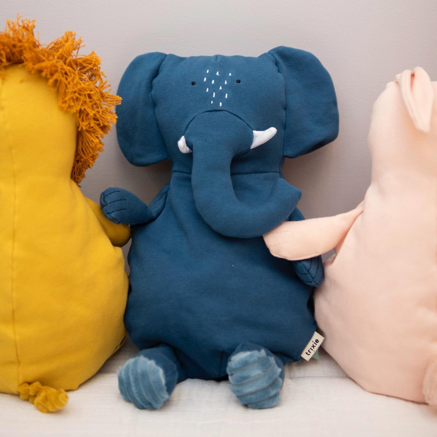 Trixie Mrs. Elephant | Organic Plush Toy | Lifestyle - Mrs. Elephant Organic Plush Toy Sitting with other soft toys on bench | BeoVERDE.ie