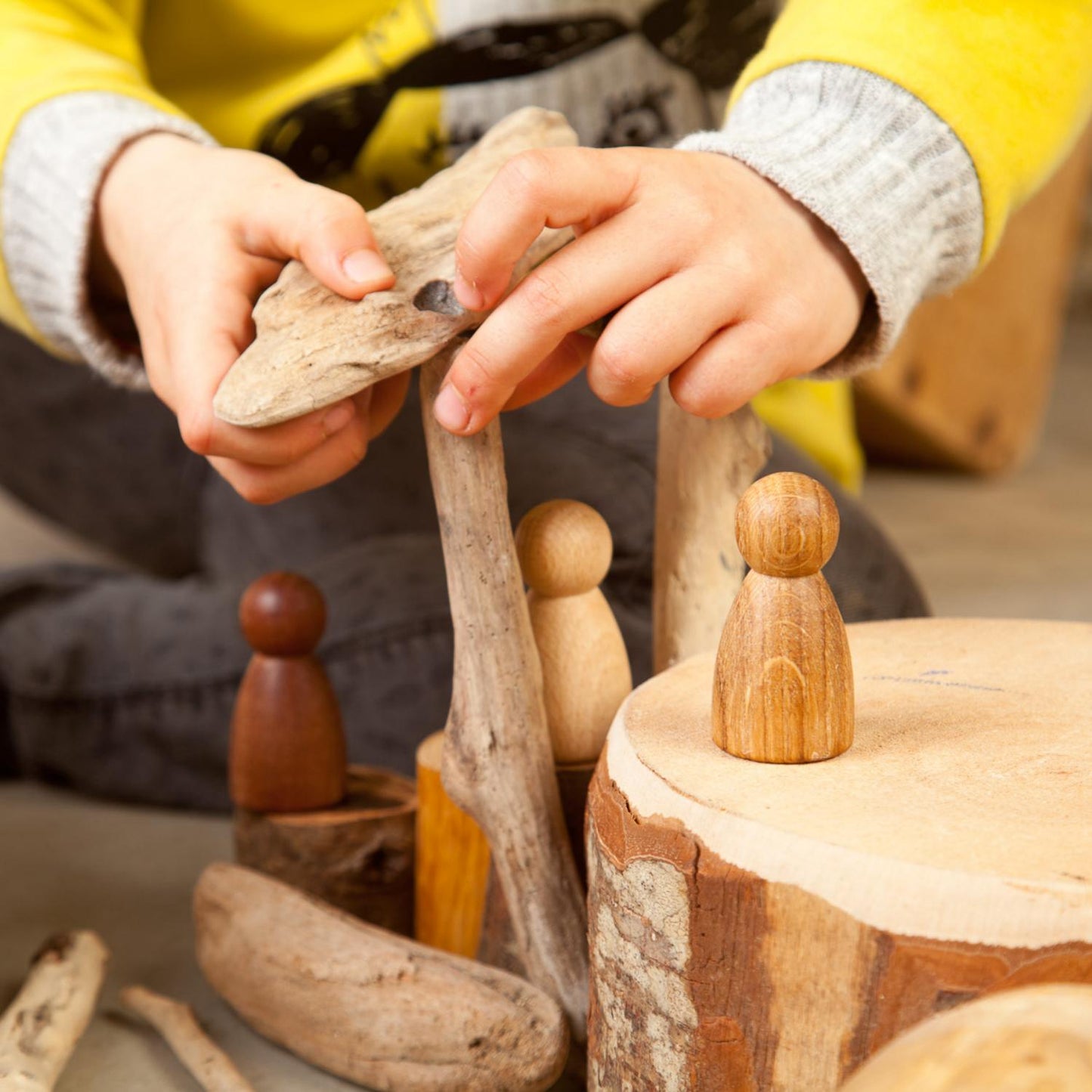 Grapat 3 Natural Woods Nins | Wooden Toys for Kids | Open-Ended Play Set | Lifestyle: Close-up Boy Playing with Nins in Natural Woods on the Floor | BeoVERDE.ie