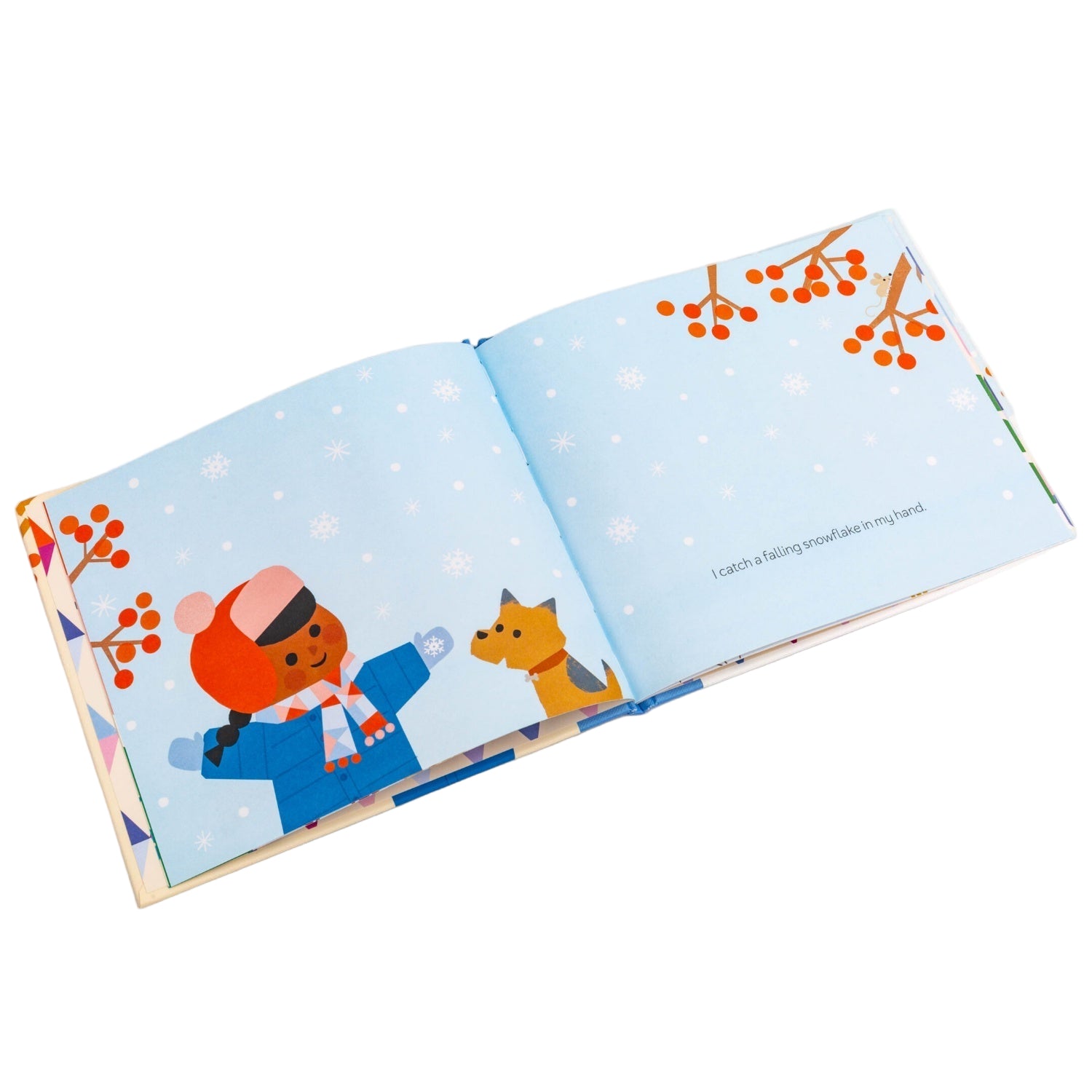 Illustrated book open to a page with two characters in winter clothing on a snowy background.