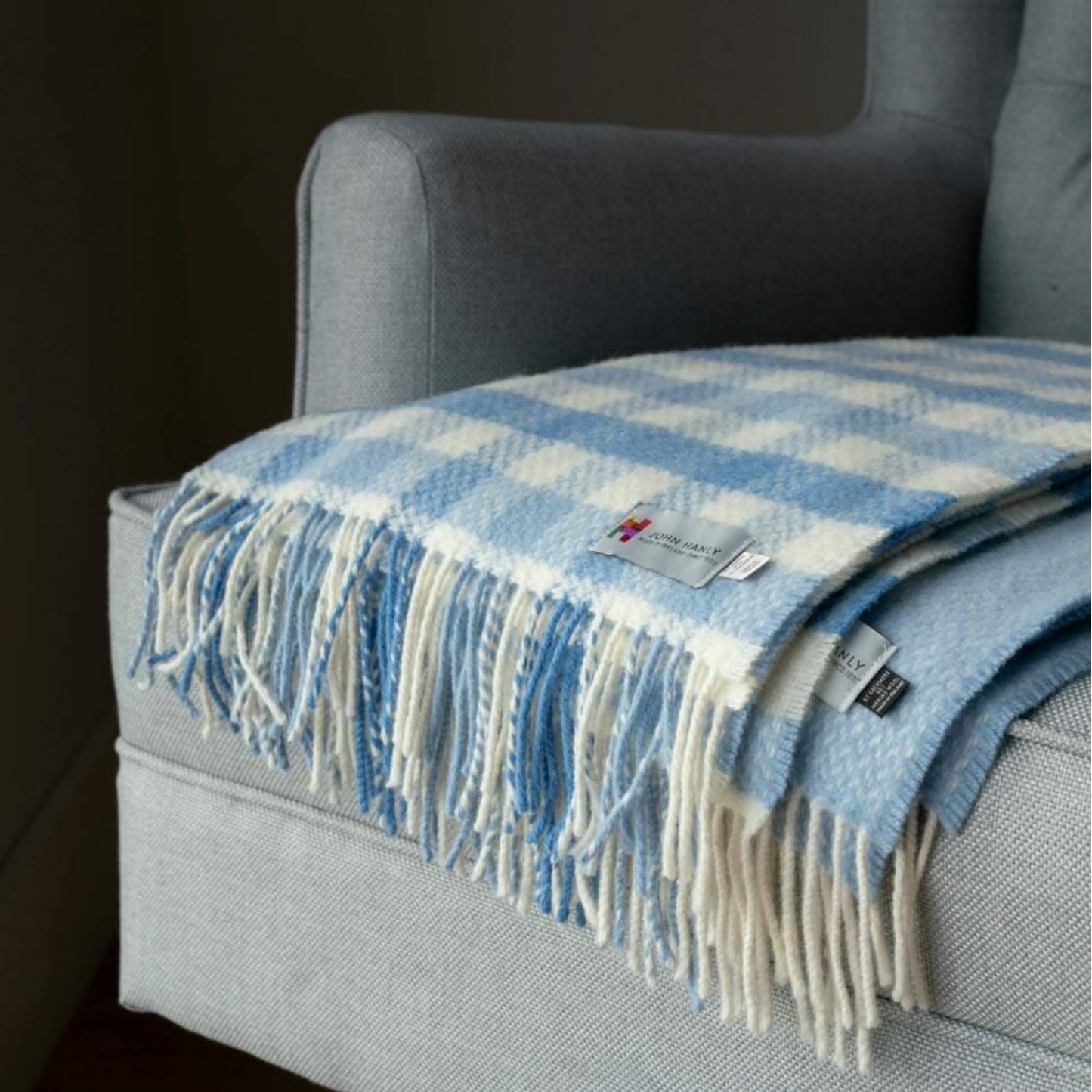 John Hanly Irish Cashmere Baby Blanket | Blue Block Check Pattern | Cashmere Blanket | Lifestyle: Blanket on Sofa | BeoVERDE Ireland