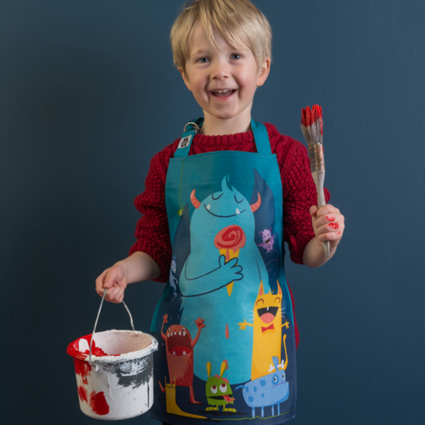 ThreadBear Design Children’s Apron ‘The Scruffles’ | Boy Wearing Apron And Holding A Paint Brush | BeoVERDE.ie