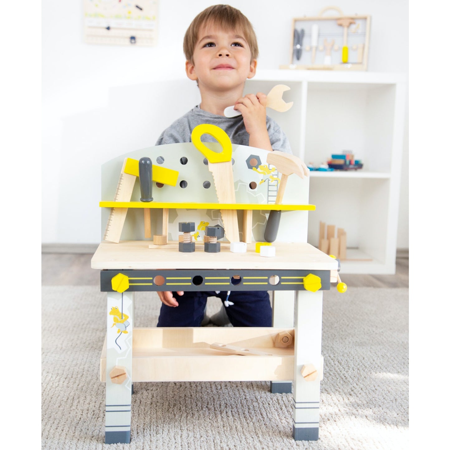 Small Foot Kid’s Tool Bench Set | Wooden Pretend Play Tools & Toy Workbench | Lifestyle - Boy Kneeling Behind Workbench | BeoVERDE.ie