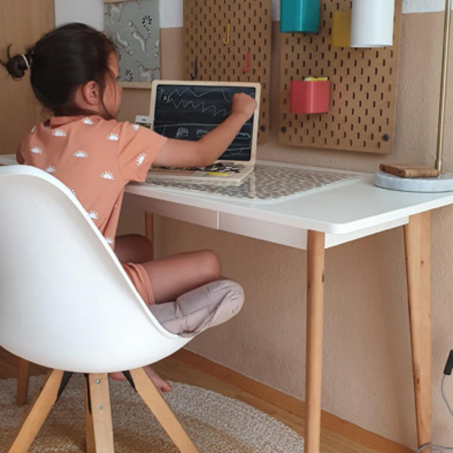 Small Foot 2-in-1 Magnetic Wooden Blackboard Laptop | Wooden Educational Toy | Lifestyle: Girl Sitting at Desk and Drawing on Blackboard | BeoVERDE.ie